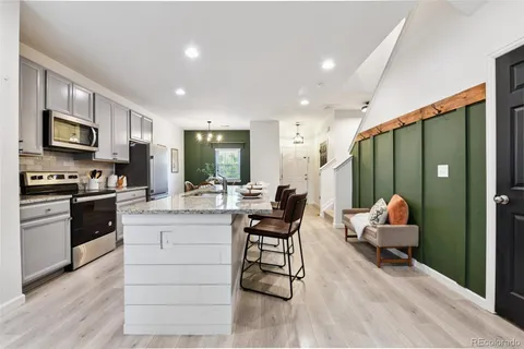 a kitchen with stainless steel appliances kitchen island granite countertop a stove and cabinets