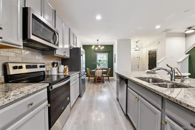 a kitchen with stainless steel appliances granite countertop a sink stove and cabinets