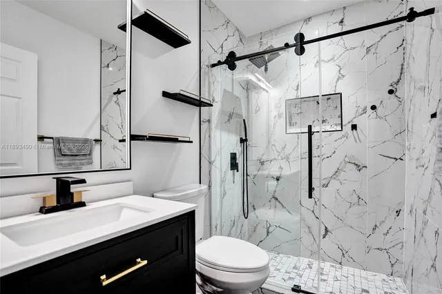 a bathroom with a sink toilet vanity and shower