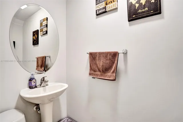 a bathroom with a toilet a sink and mirror