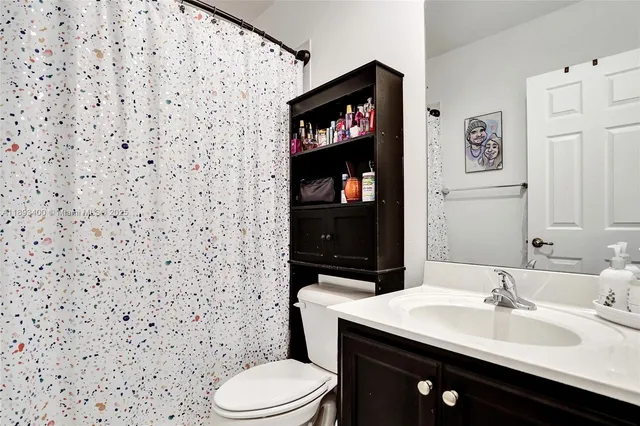 a bathroom with a sink a toilet and a mirror