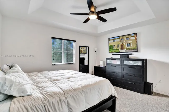a bedroom with a bed and a flat tv screen on dresser