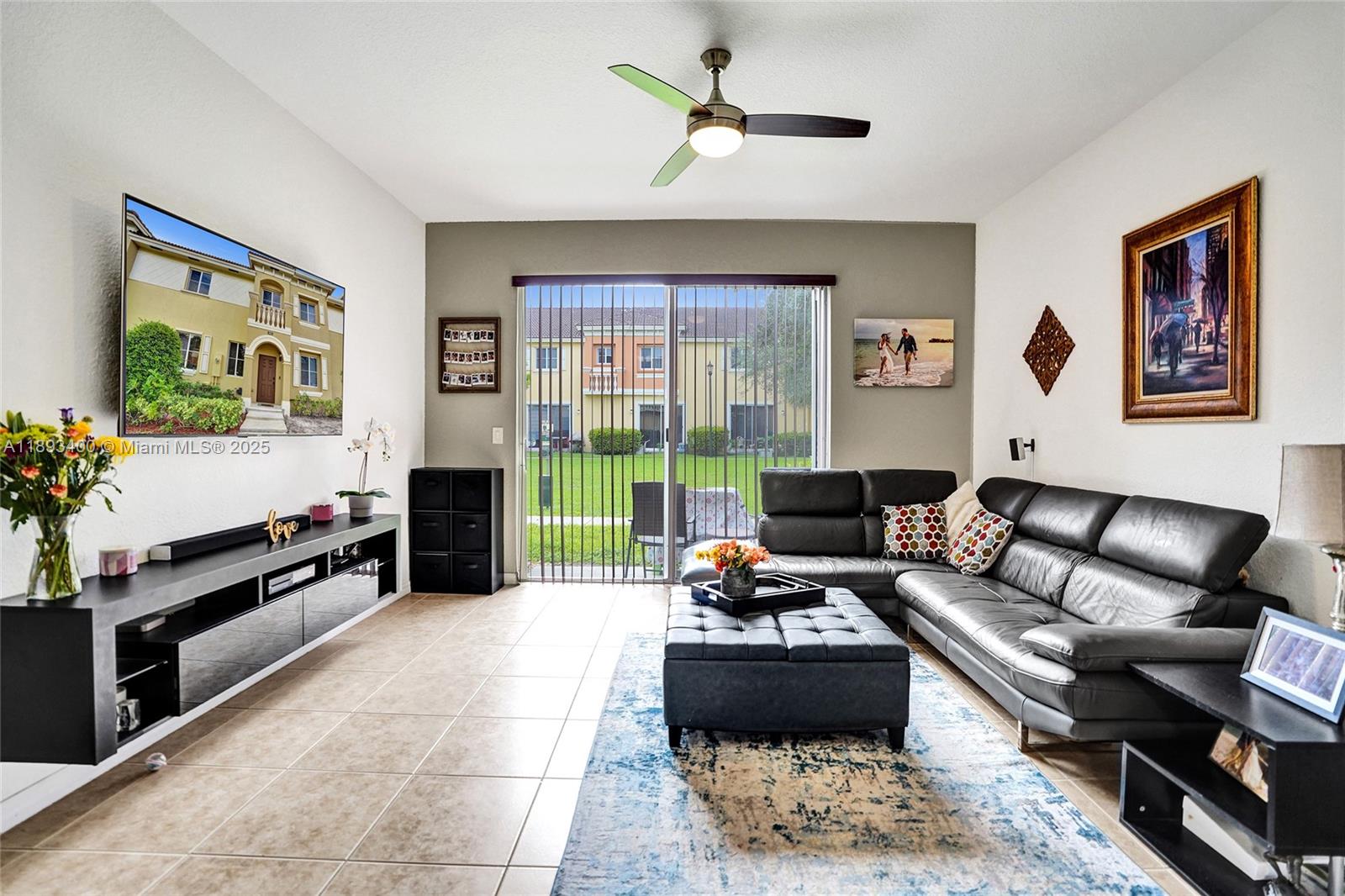 1832 Southwest 89th Terrace Miramar, FL 33025 - Photo 10 of 28 a living room with furniture a flat screen tv and a floor to ceiling window