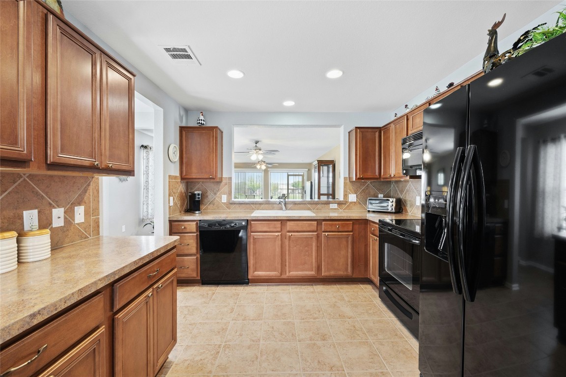 104 Monument Hill Trail Georgetown, TX 78633 - Photo 10 of 27 a large kitchen with stainless steel appliances granite countertop a refrigerator a sink dishwasher a stove and a sink