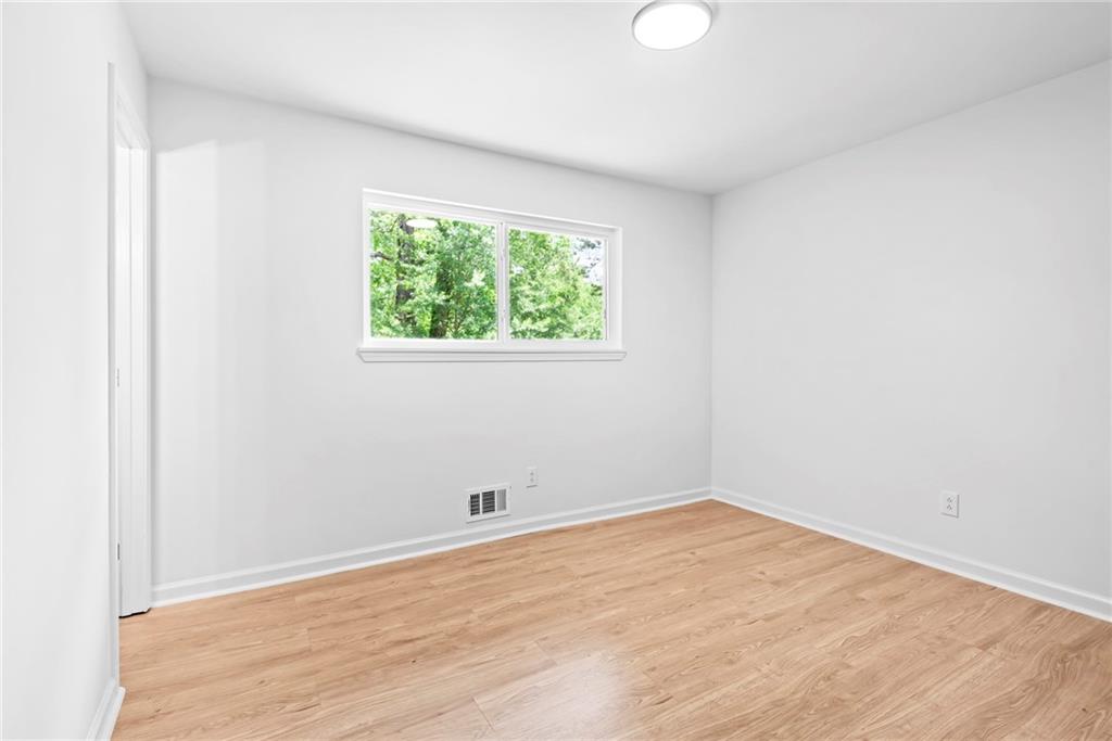 264 Howell Terrace Southwest Atlanta, GA 30331 - Photo 18 of 22 an empty room with wooden floor and windows