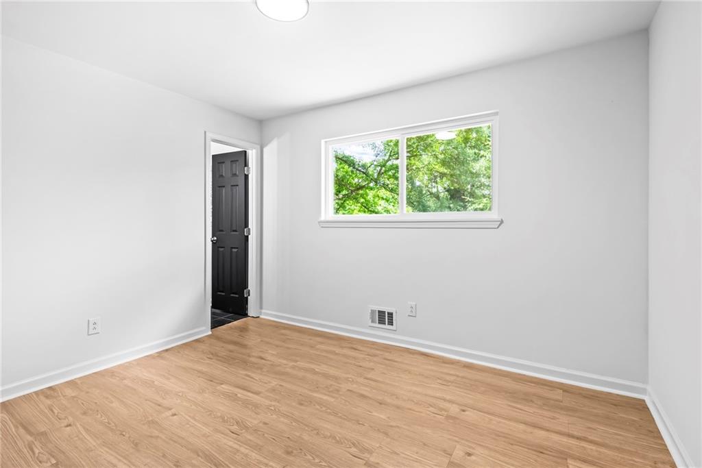 264 Howell Terrace Southwest Atlanta, GA 30331 - Photo 20 of 22 an empty room with wooden floor and windows