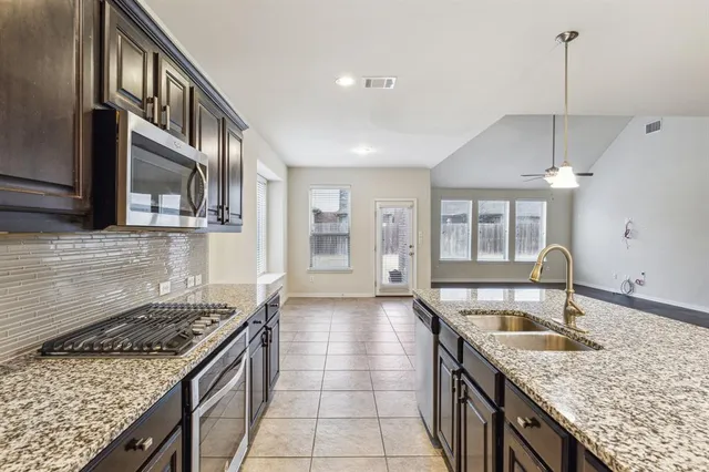 a kitchen with stainless steel appliances granite countertop a sink stove and cabinets