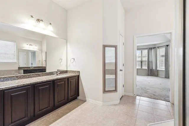 a spacious bathroom with a granite countertop sink mirror and