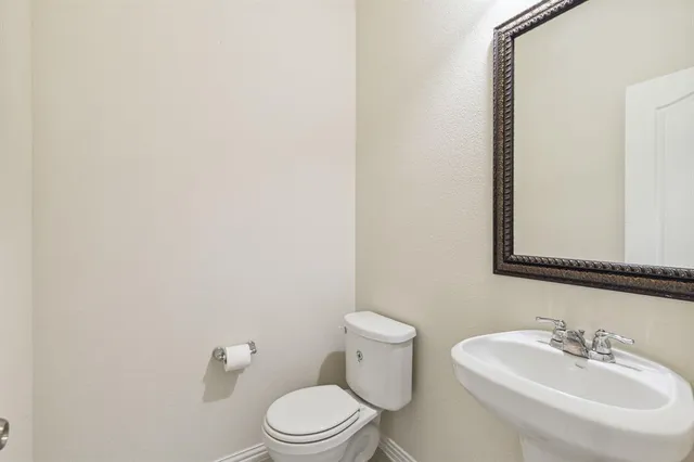 a bathroom with a toilet a sink and mirror