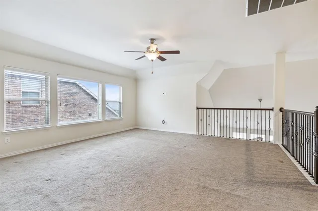 a view of a big room with windows and chandelier fan