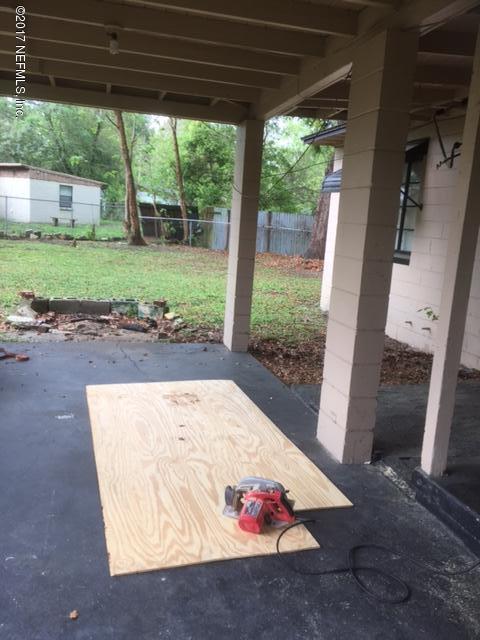 1427 King Arthur Road Jacksonville, FL 32211 - Photo 25 of 37 a view of a backyard with large trees and a wooden fence