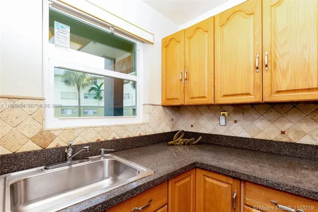 a kitchen with stainless steel appliances granite countertop a sink a granite counter tops and a window