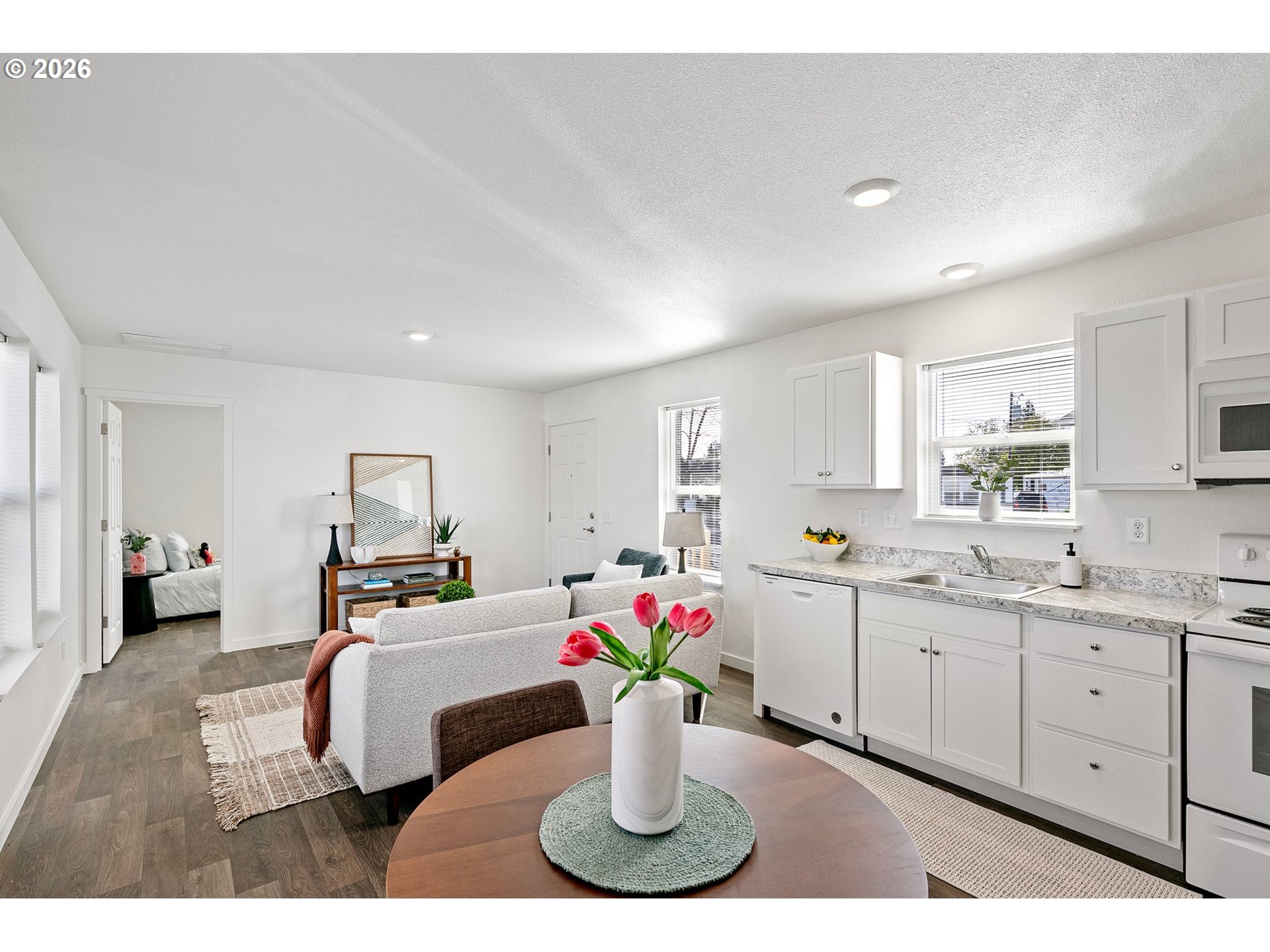 1085 West 1st Avenue, Unit R Junction City, OR 97448 - Photo 11 of 14 a kitchen with a sink dishwasher and a dining table with wooden floor