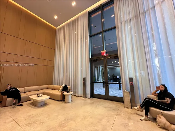 a living room with furniture a window and a glass door shower