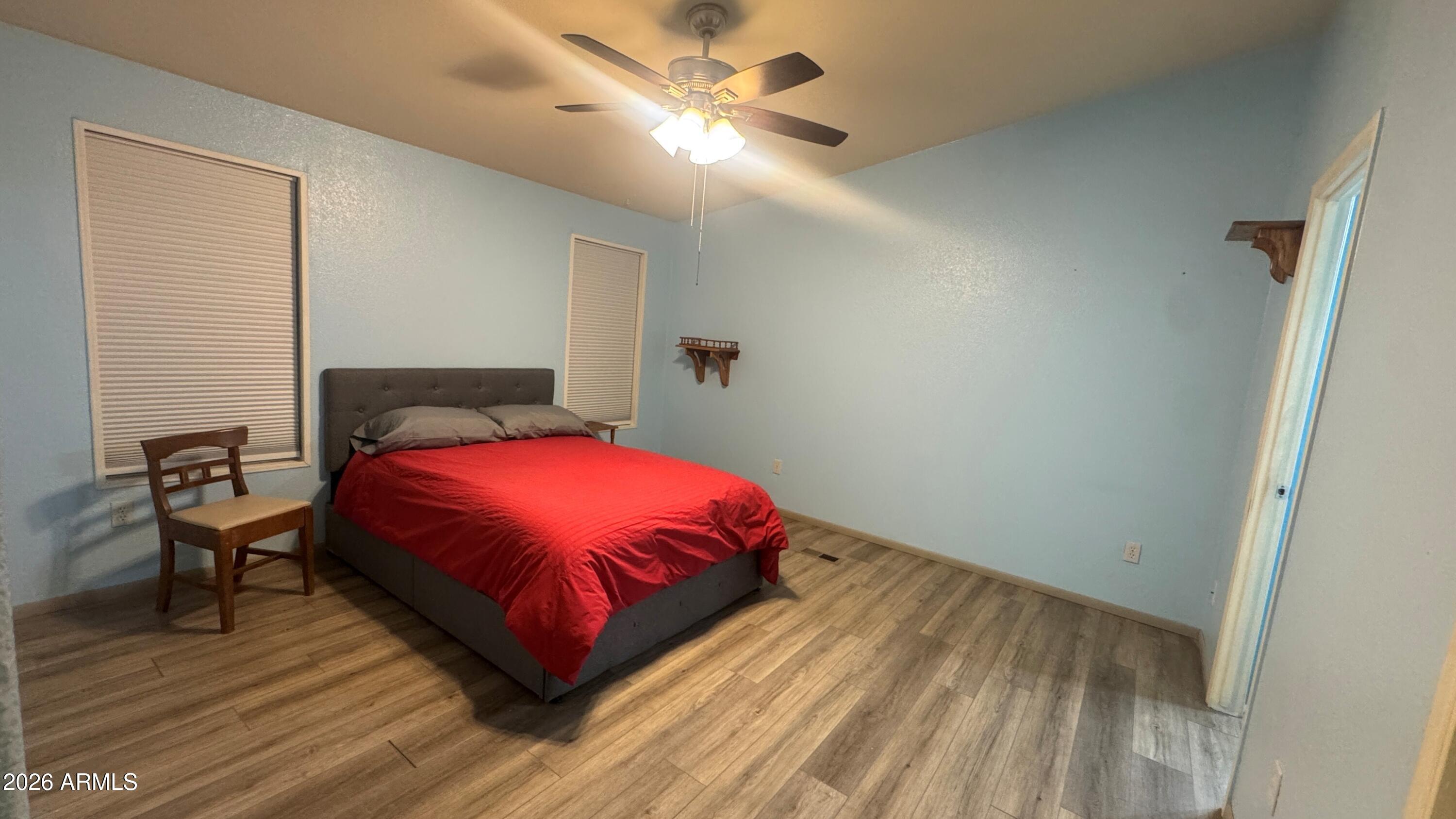 3700 South Tomahawk Road, Unit 95 Apache Junction, AZ 85119 - Photo 11 of 31 a bedroom with a bed and a chandelier