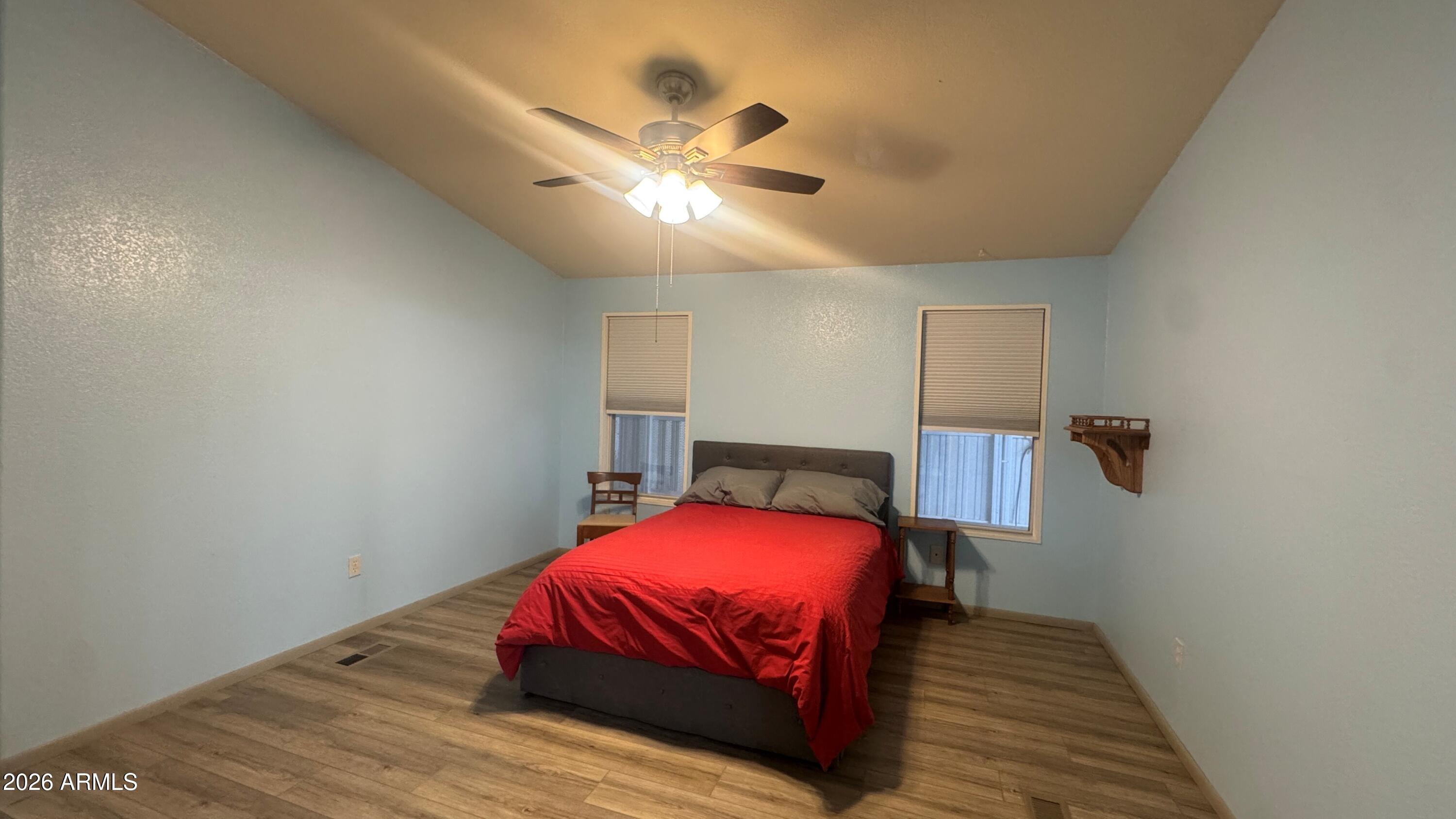 3700 South Tomahawk Road, Unit 95 Apache Junction, AZ 85119 - Photo 12 of 31 a bedroom with a bed and wooden floor