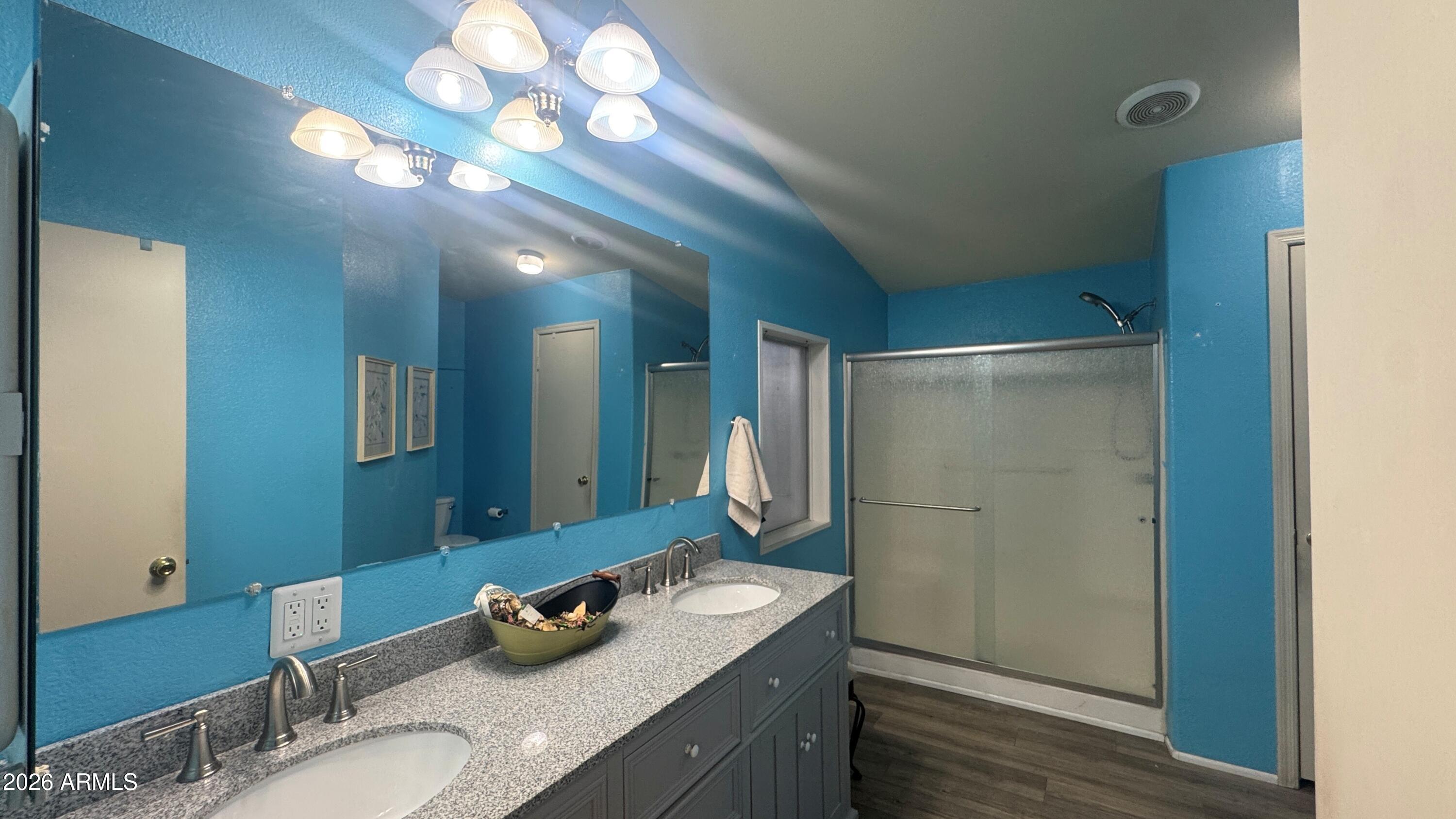 3700 South Tomahawk Road, Unit 95 Apache Junction, AZ 85119 - Photo 14 of 31 a bathroom with a granite countertop sink a large mirror and shower