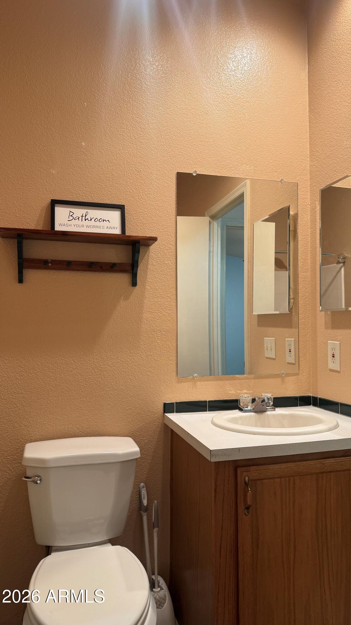 3700 South Tomahawk Road, Unit 95 Apache Junction, AZ 85119 - Photo 19 of 31 a bathroom with a sink a toilet and mirror