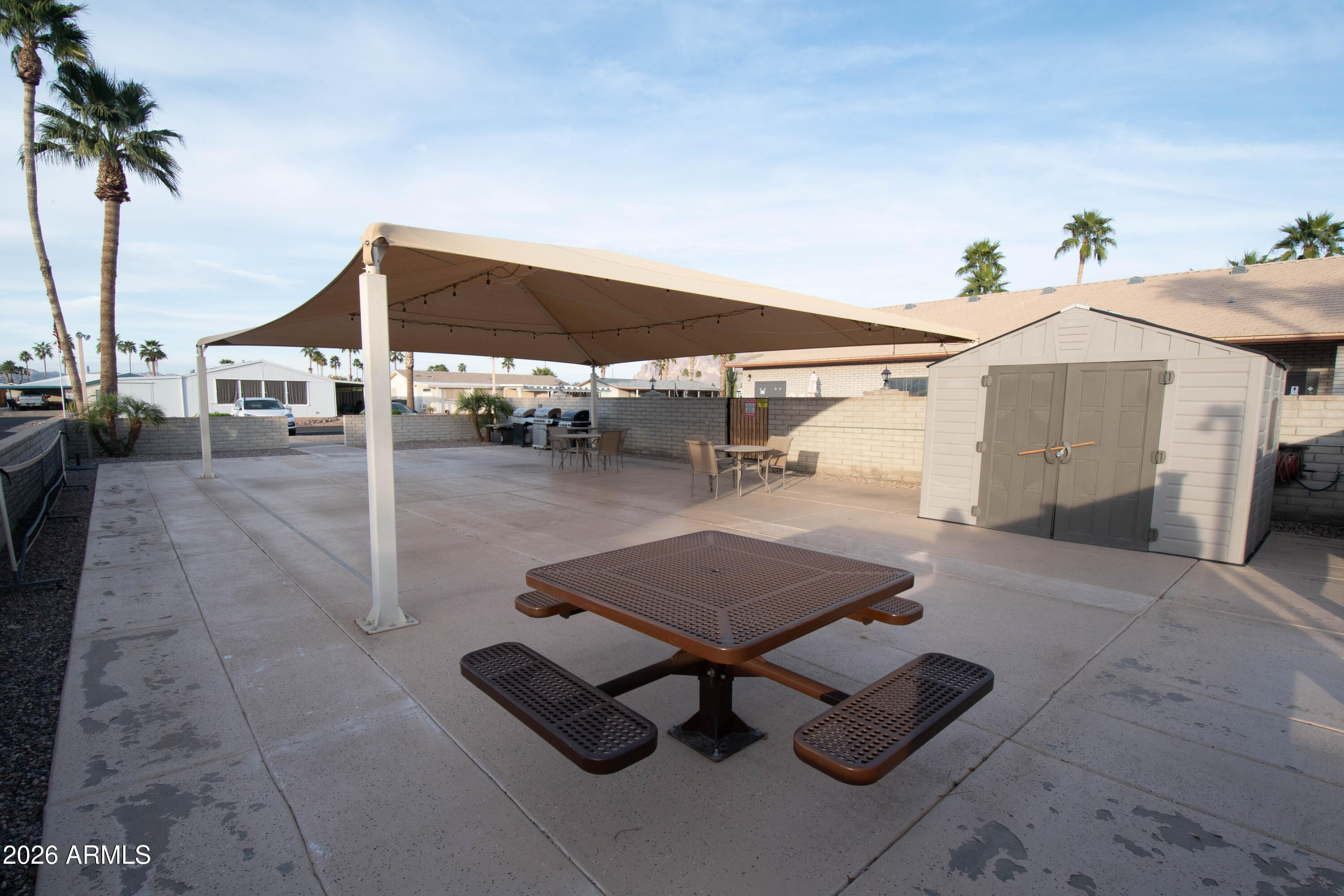 3700 South Tomahawk Road, Unit 95 Apache Junction, AZ 85119 - Photo 29 of 31 a view of a patio with a table and chairs under an umbrella