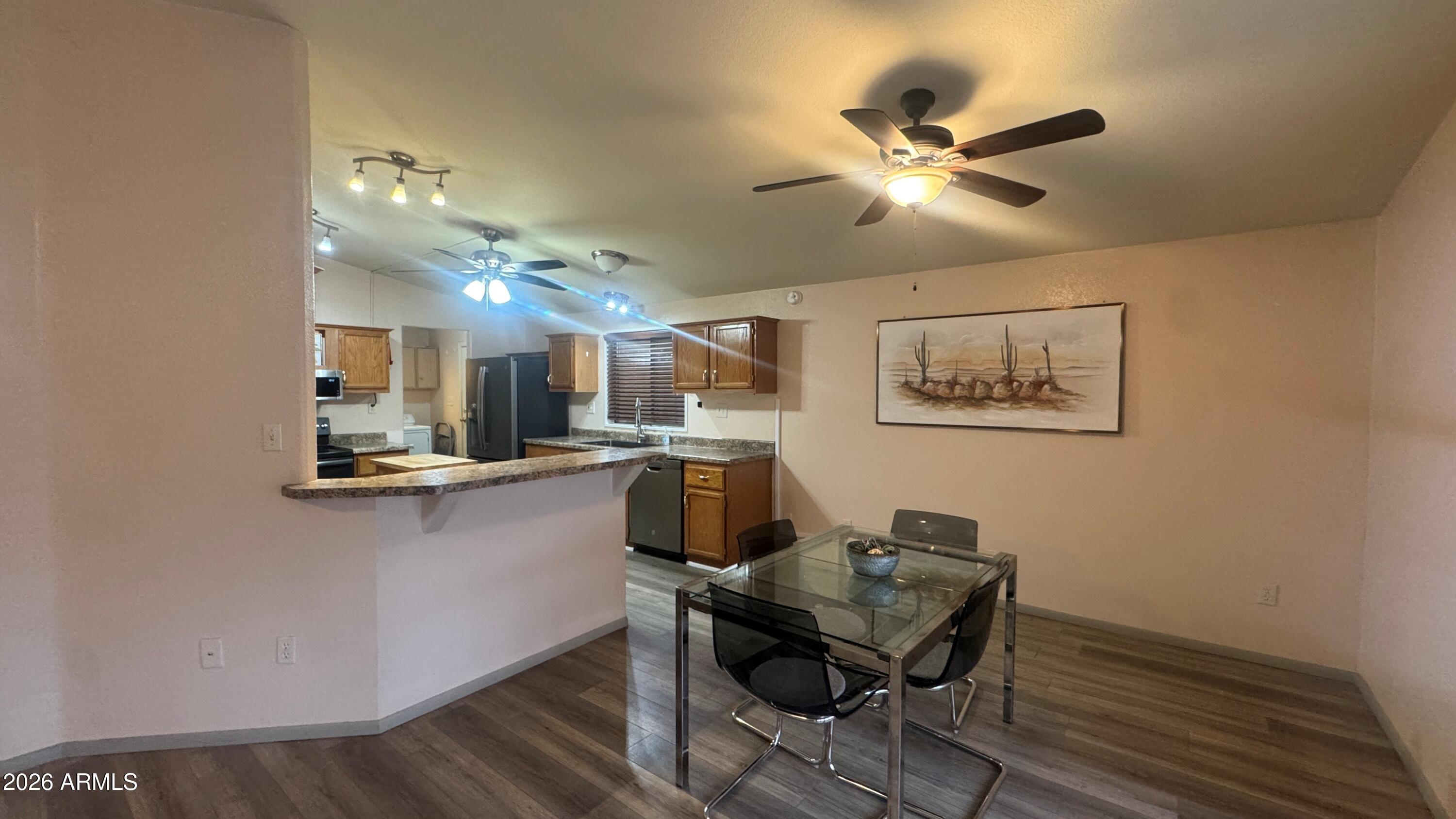 3700 South Tomahawk Road, Unit 95 Apache Junction, AZ 85119 - Photo 6 of 31 a workspace with wooden floor and chandelier