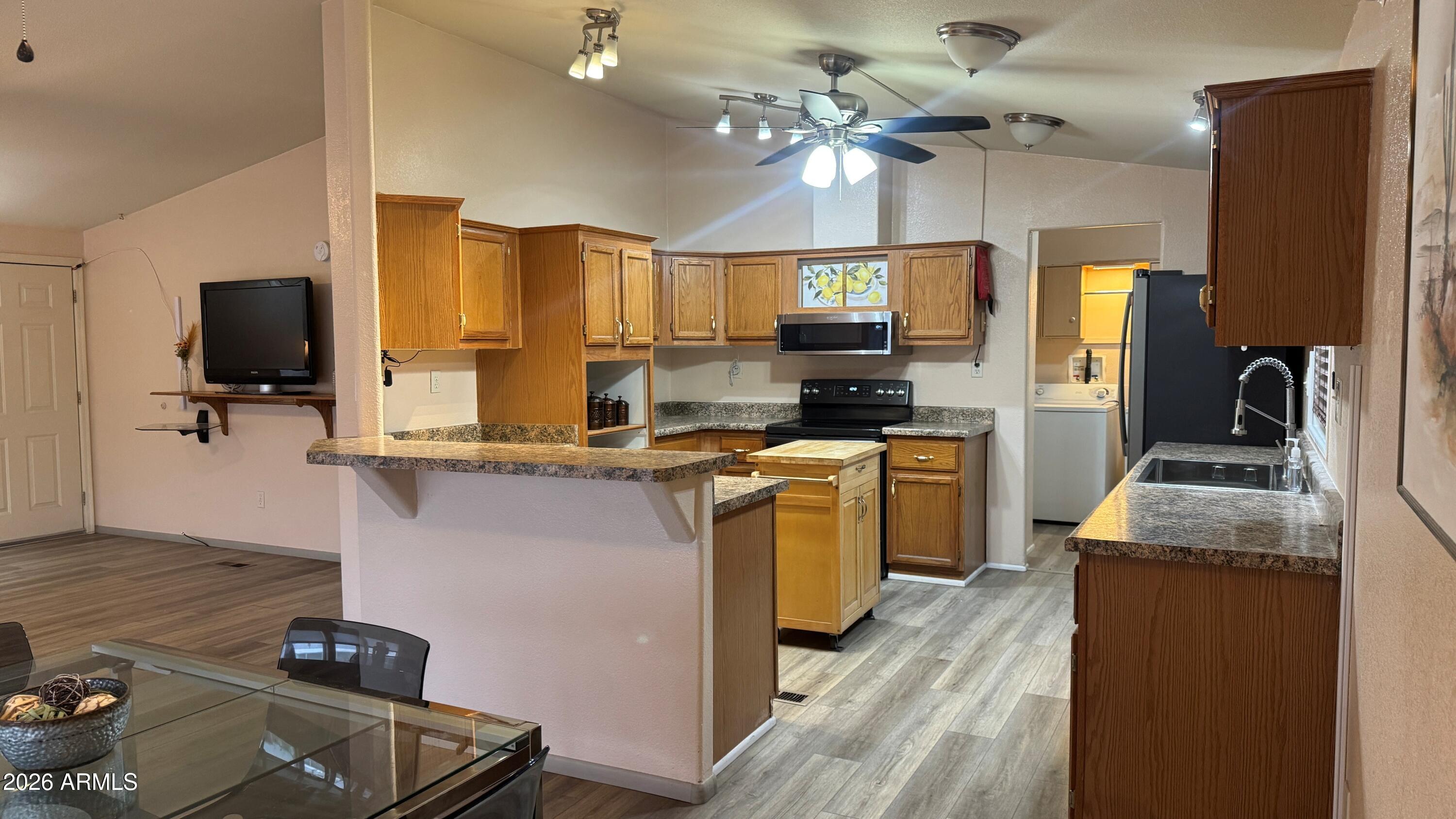 3700 South Tomahawk Road, Unit 95 Apache Junction, AZ 85119 - Photo 7 of 31 a kitchen with kitchen island granite countertop a sink appliances cabinets and a counter top space