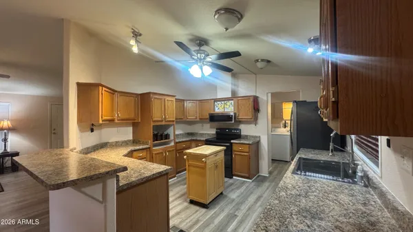 a kitchen with granite countertop kitchen island stainless steel appliances a sink stove and refrigerator