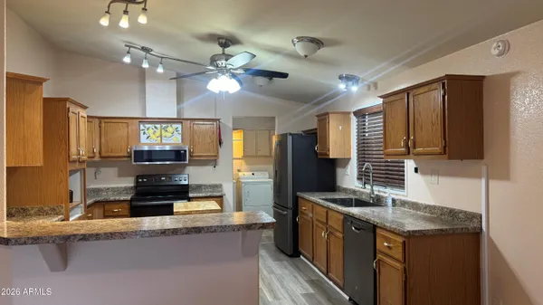 a kitchen with stainless steel appliances granite countertop a sink a stove and a refrigerator