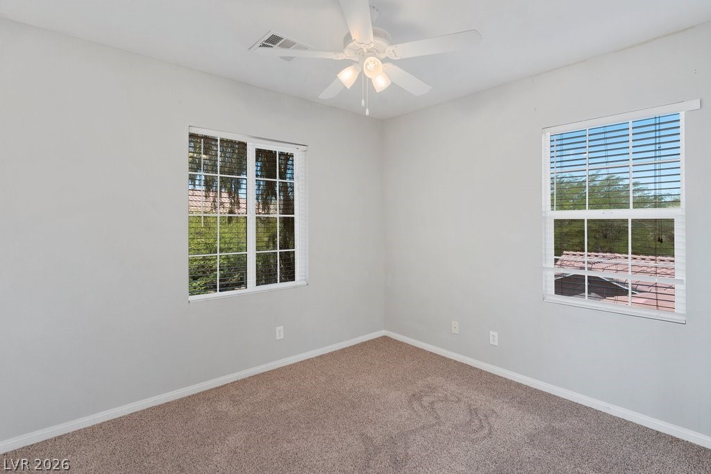 10336 Hawk Ravine Street Las Vegas, NV 89178 - Photo 41 of 59 Bright and airy, this room provides comfort and potential for personalization.