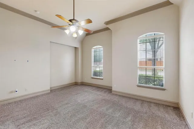 an empty room with windows and ceiling fan
