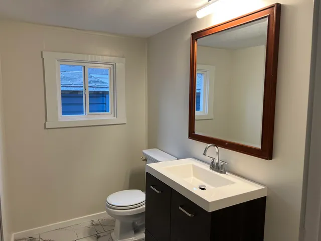 a bathroom with a toilet sink and mirror
