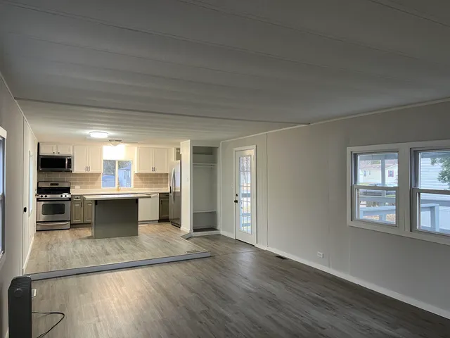 an empty room with a fireplace and windows