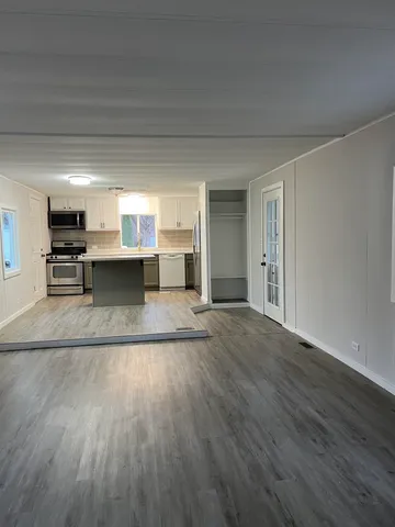 a view of a kitchen with wooden floor and a window