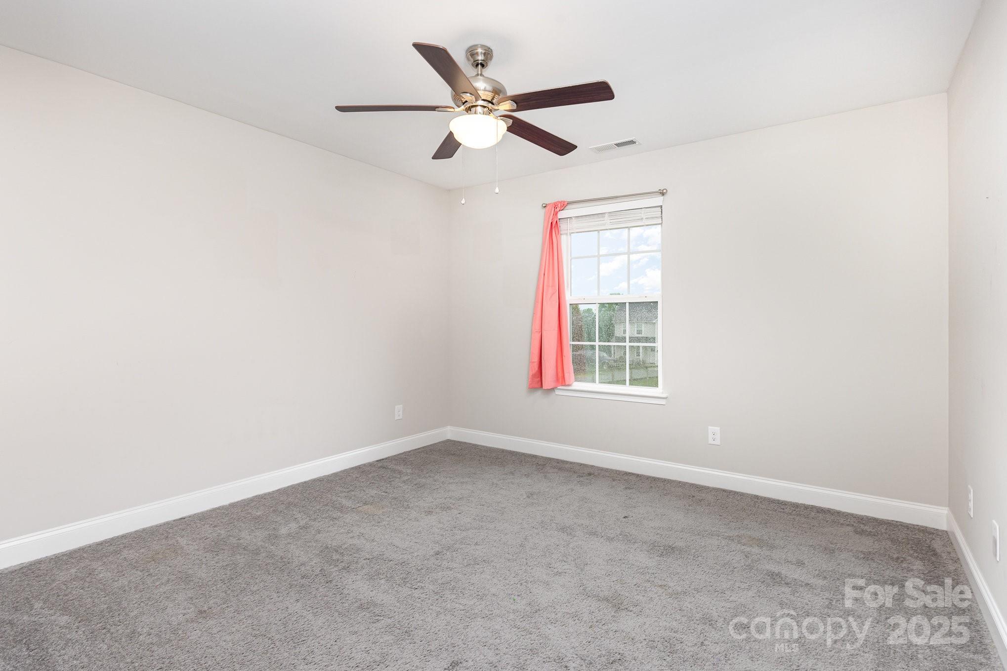 4026 Pigg Mattox Road Monroe, NC 28112 - Photo 25 of 31 an empty room with ceiling fan and windows