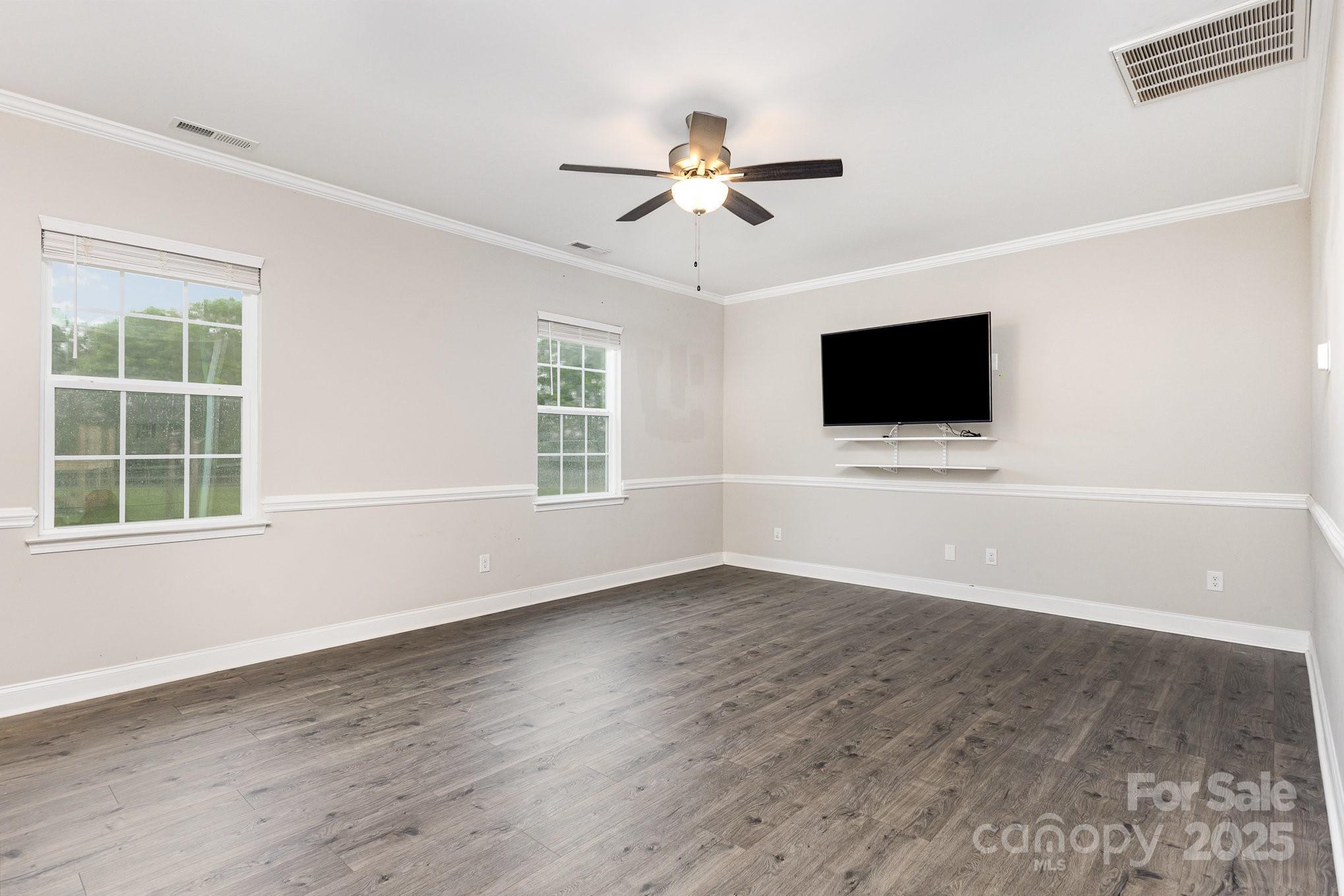 4026 Pigg Mattox Road Monroe, NC 28112 - Photo 5 of 31 a view of a livingroom with a flat screen tv ceiling fan and wooden floor