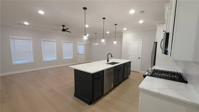 a kitchen with kitchen island a sink stainless steel appliances and refrigerator