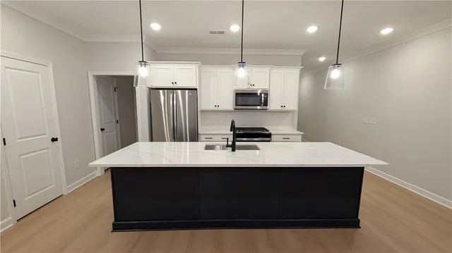 a kitchen with stainless steel appliances a refrigerator a sink a stove a microwave and island