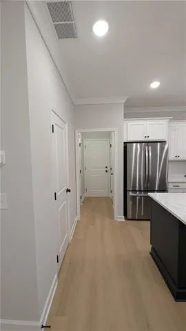 a view of an empty room with chandelier fan and fire place