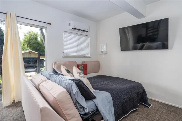 a bedroom with a bed and a flat screen tv