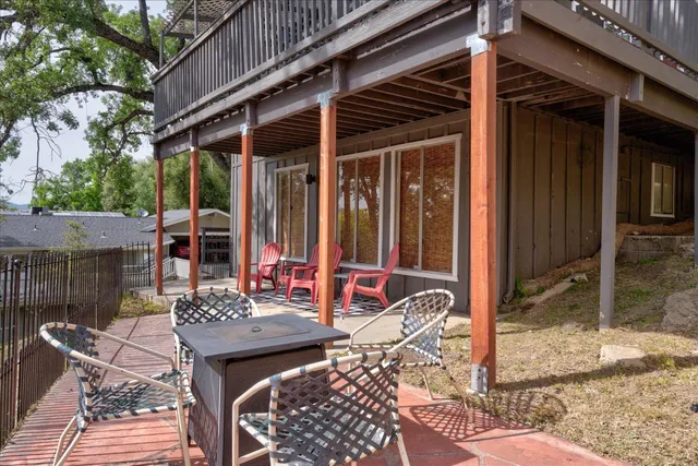 a view of a patio with table and chairs and wooden fence