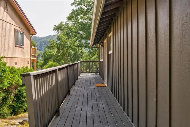 a view of balcony with wooden floor and fence and trees