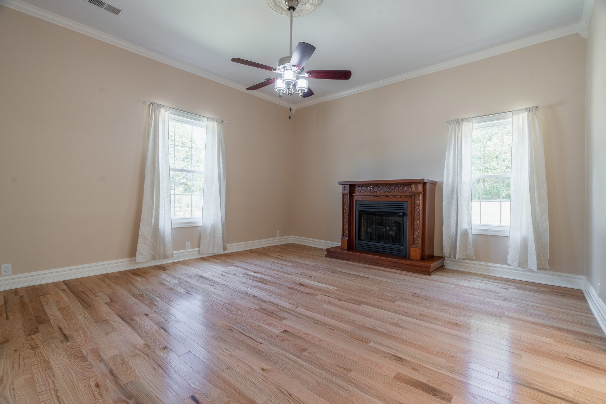 4870 Chicken Road Lebanon, TN 37090 - Photo 6 of 50 a view of an empty room with wooden floor fireplace and a window