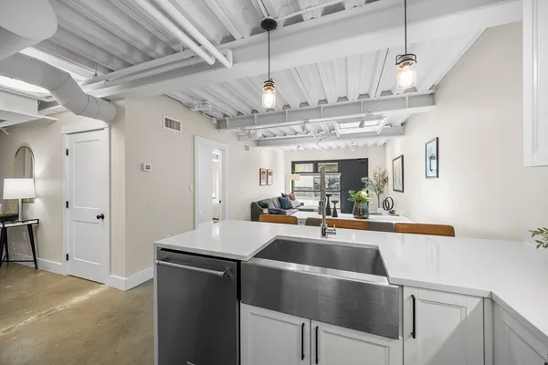 a view of a kitchen with a sink and chandelier