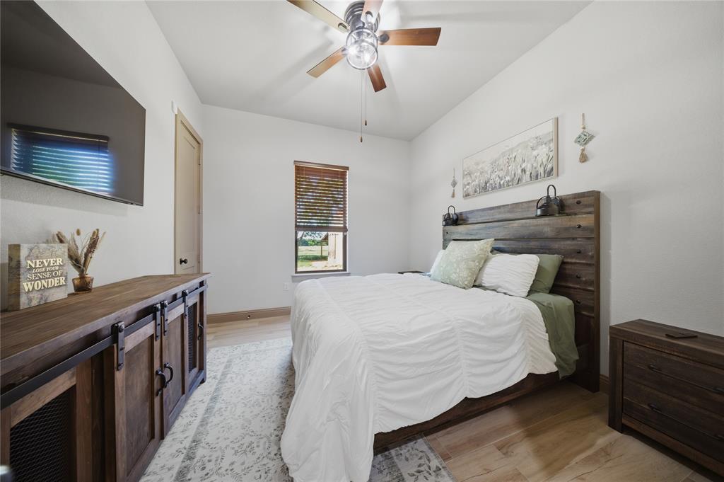 958 Cedar Mills Road Gordonville, TX 76245 - Photo 26 of 40 a bedroom with a bed and a chandelier