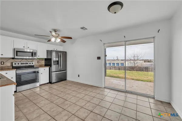a kitchen with stainless steel appliances granite countertop a refrigerator and a stove top oven