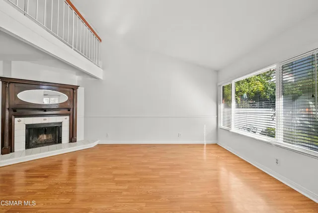 a view of empty room with wooden floor and fireplace