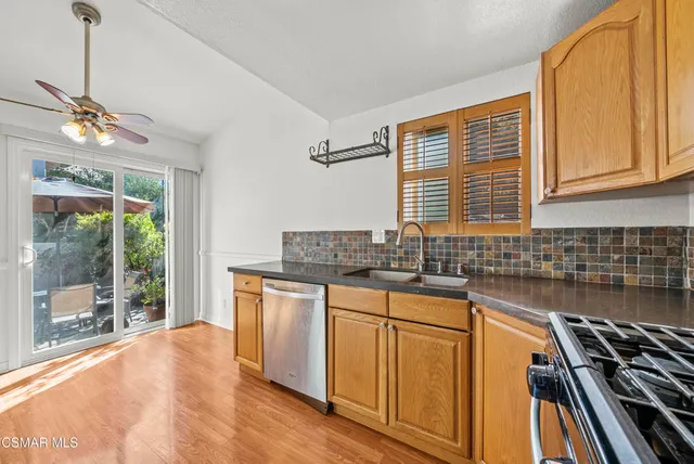 a kitchen with stainless steel appliances granite countertop a stove a sink dishwasher and a microwave oven with cabinets