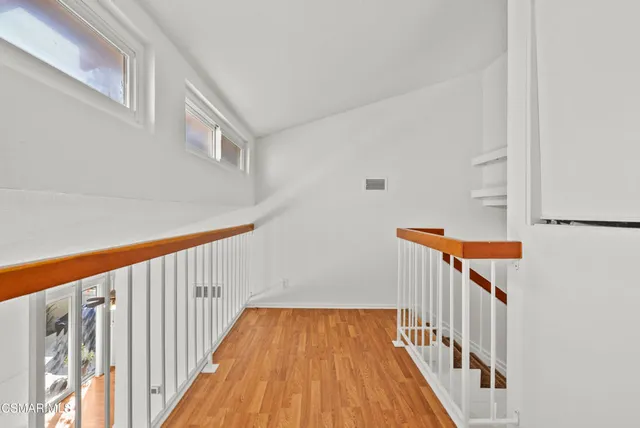 a view of staircase with railing and white walls