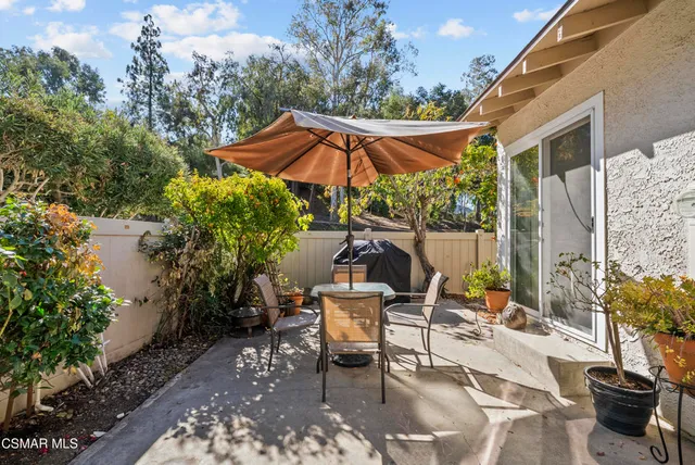 a view of a patio with table and chairs under an umbrella