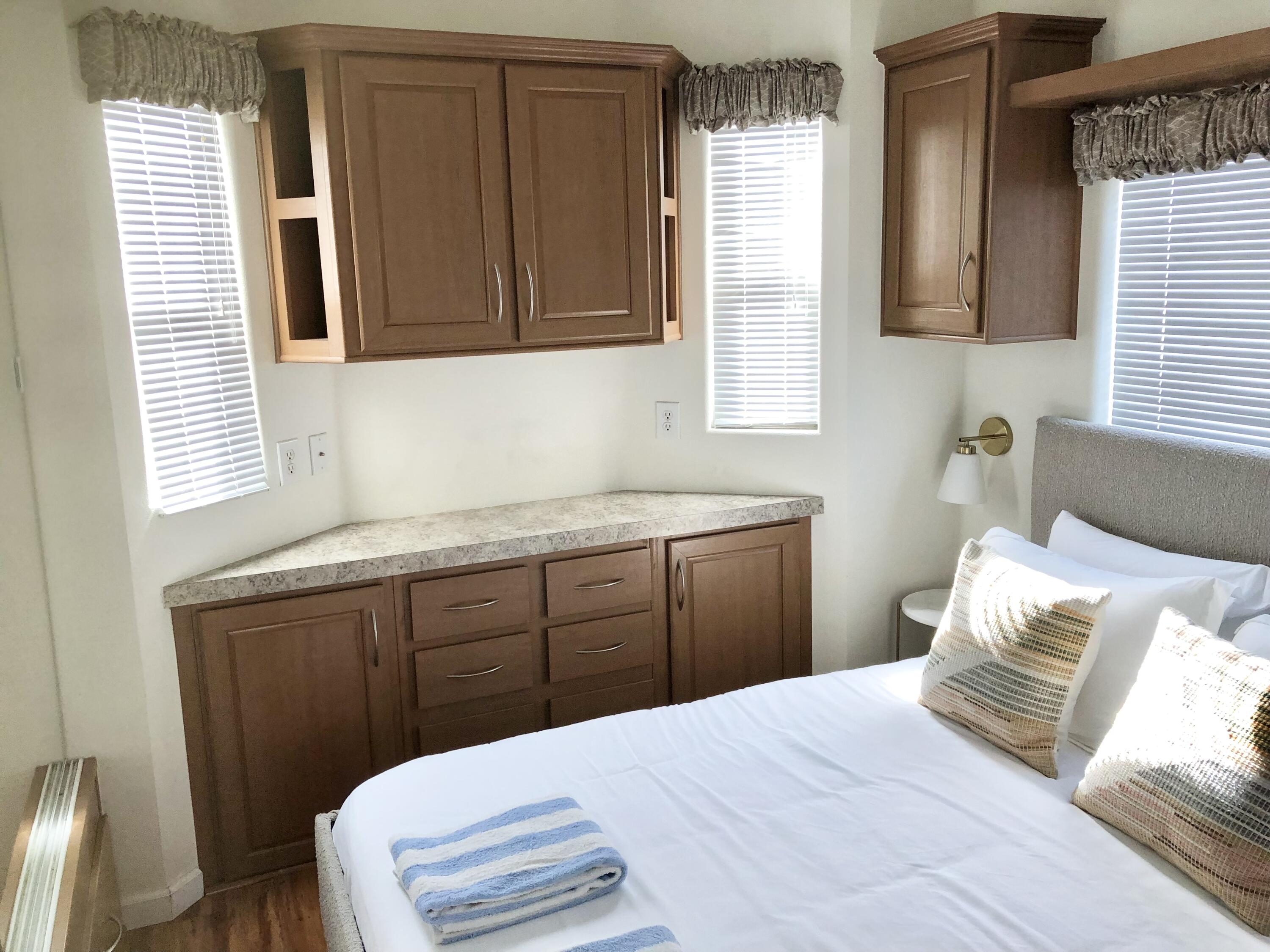 74711 Dillon Road Desert Hot Springs, CA 92241 - Photo 15 of 38 a bedroom with a bed and wooden cabinets