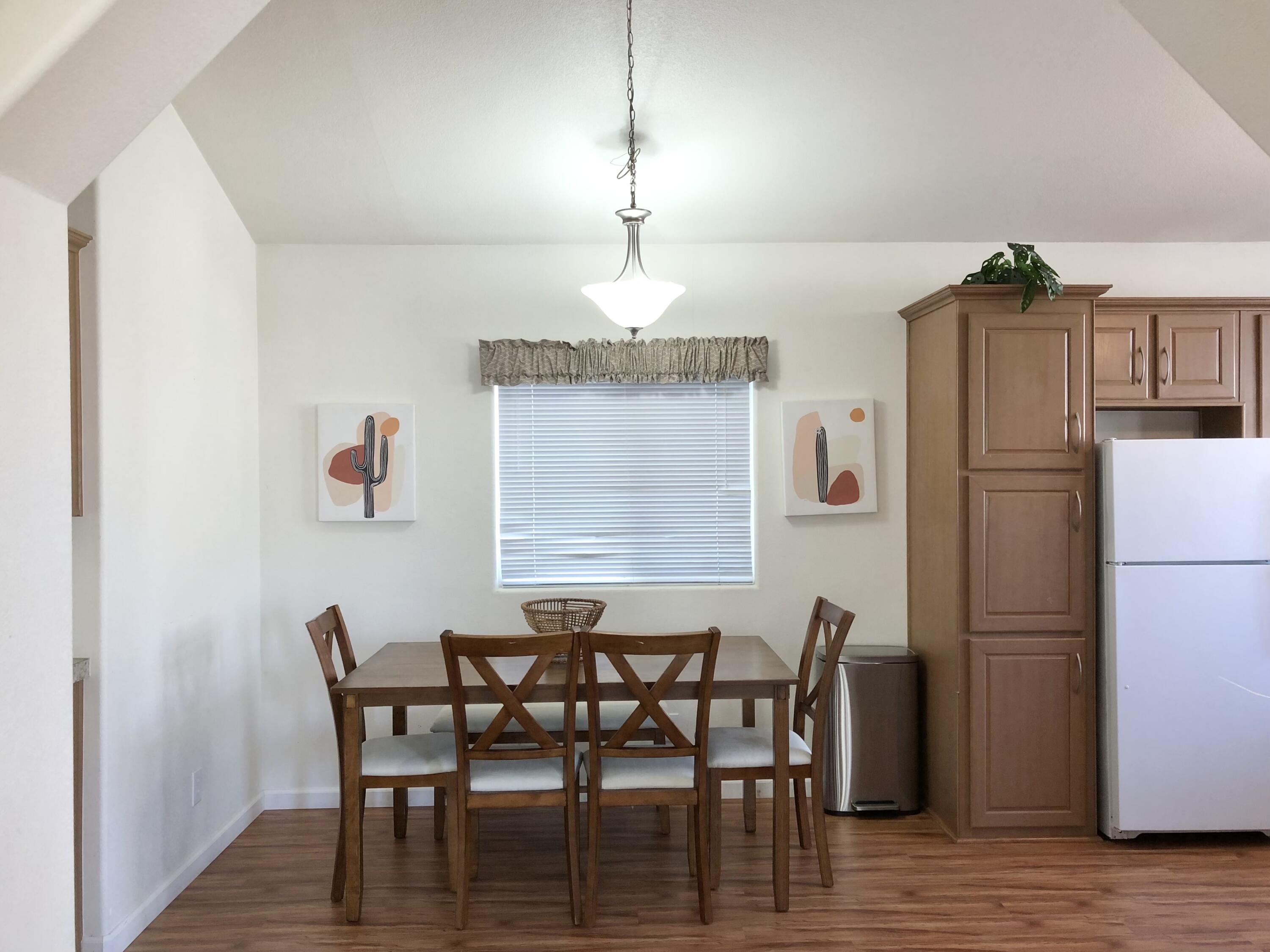 74711 Dillon Road Desert Hot Springs, CA 92241 - Photo 2 of 38 a dining room with furniture a chandelier and wooden floor